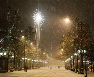 Snowy street scene in Seattle during heavy snowfall of December 2008. Macy's department store's illuminated star of Bethlehem and round street lamps shine through the falling snow.
