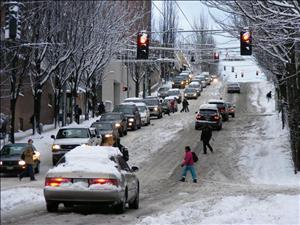 Cars and pedestrians struggle through snow on downtown Seattle street on December 22, 2008