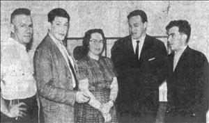 A younger Lavroff in a flannel suit jacket posing with four other people in business attire