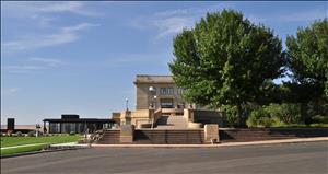 The Maryhill Museum as seen from the parking lot, with beige stone steps and tall iron lights leading the way to the museum entrance with a low, international style extension to the museum visible on the left side