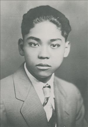 Young Japanese-American man in a suit poses for a portrait
