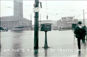 View of intersection of 4th Ave S. and S. Jackson street, Union Station in background, Seattle's first automatic traffic-control light suspended from utility poles.