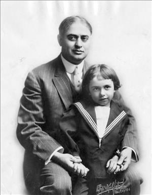 Pantages posing with child in a navy uniform