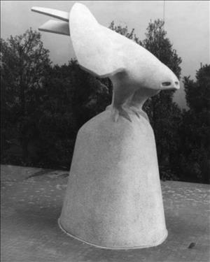 A smooth, contoured sculpture of a large bird perched on a dome-like rock