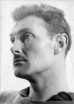 Close headshot of Graves wearing a mustache, sweater and polo shirt