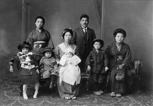 Black and white portrait of a family of 8 adults and children in traditional Japanese clothing
