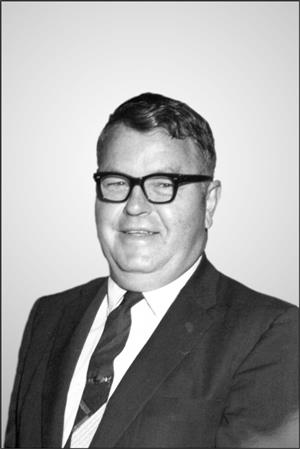 Man posing in thick rim glasses, suit and tie